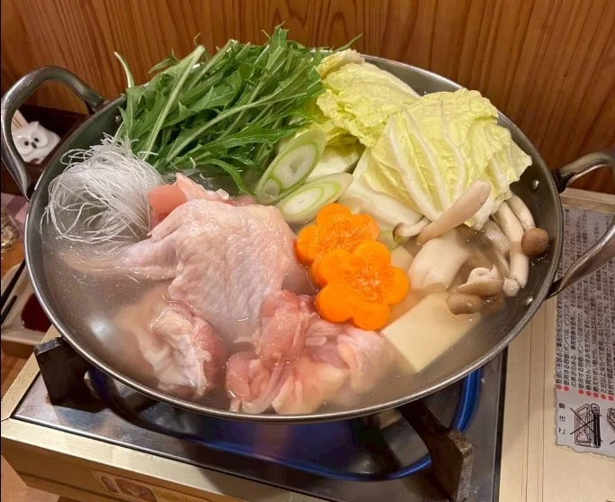 鶏肉と野菜、土鍋を並べた水炊きの食材